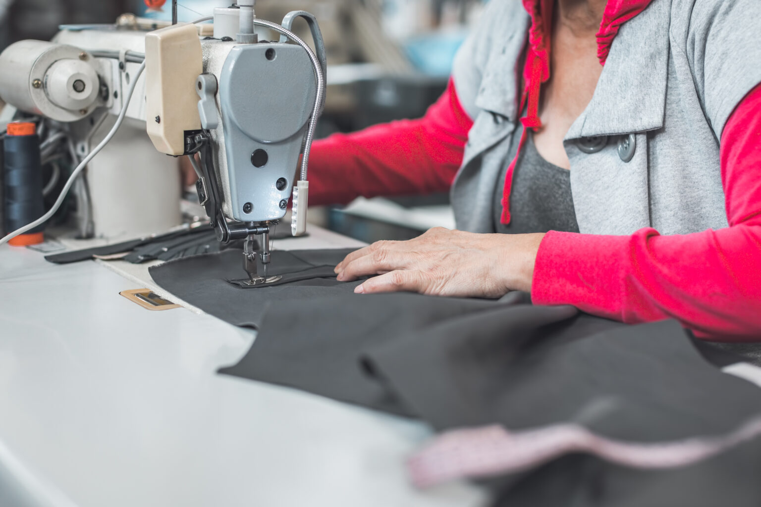 worker working on sewing machine in clothing industry